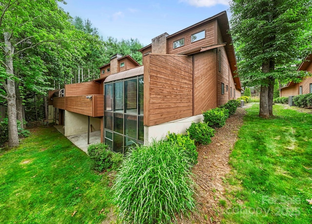 204 Woodfield Dr, Asheville, NC 28803 - view of home's exterior featuring a lawn and a sunroom