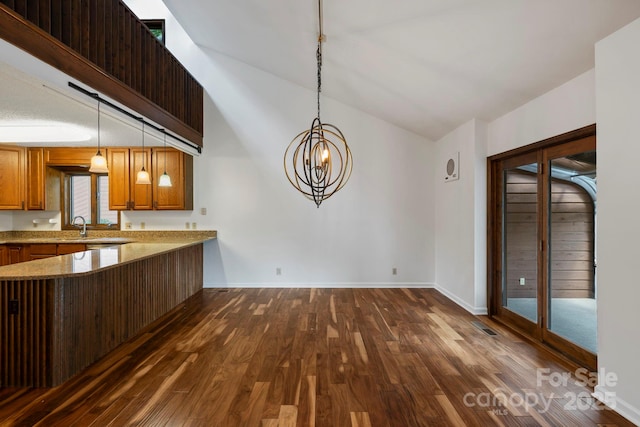 204 Woodfield Dr, Asheville, NC 28803 - kitchen with dark wood-type flooring, brown cabinets, pendant lighting, a peninsula, and high vaulted ceiling