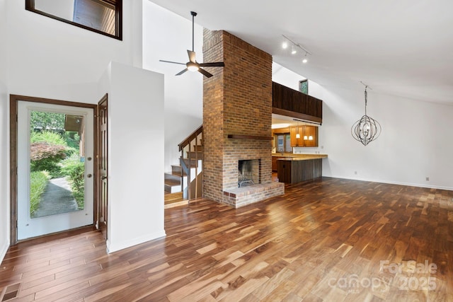 204 Woodfield Dr, Asheville, NC 28803 - unfurnished living room featuring stairs, high vaulted ceiling, track lighting, wood finished floors, and a ceiling fan