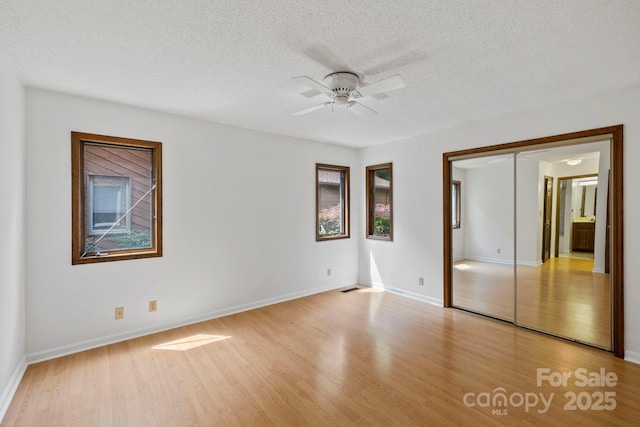 204 Woodfield Dr, Asheville, NC 28803 - unfurnished bedroom with light wood-type flooring, a textured ceiling, a closet, and ceiling fan