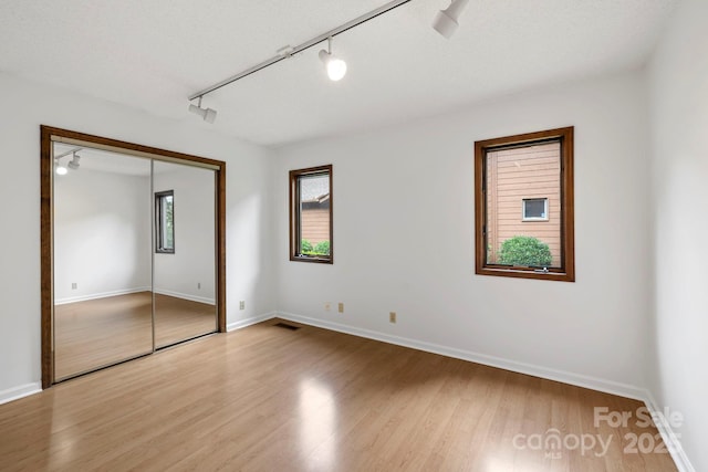 204 Woodfield Dr, Asheville, NC 28803 - unfurnished bedroom with track lighting, wood finished floors, and a closet