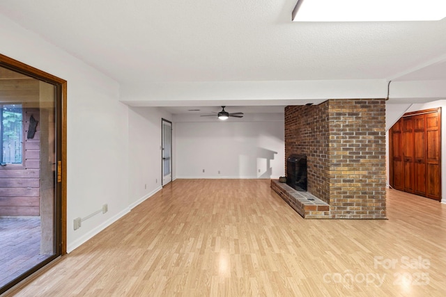 204 Woodfield Dr, Asheville, NC 28803 - unfurnished living room featuring light wood-style flooring, a brick fireplace, and a ceiling fan