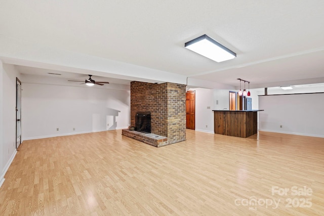 204 Woodfield Dr, Asheville, NC 28803 - unfurnished living room with bar area, light wood-style flooring, a ceiling fan, and a brick fireplace