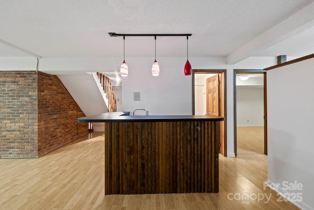 204 Woodfield Dr, Asheville, NC 28803 - kitchen featuring light wood-style flooring, brick wall, hanging light fixtures, and a center island