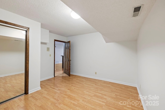 204 Woodfield Dr, Asheville, NC 28803 - unfurnished bedroom with light wood finished floors, a textured ceiling, and a closet