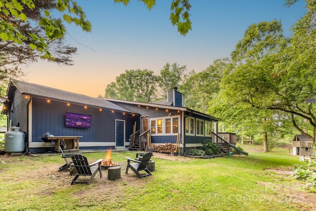 8 Briarwood Ln, Fletcher, NC 28732 - back of house with a fire pit, a chimney, stairs, a lawn, and a sunroom