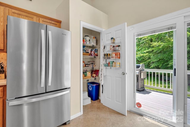 145 Fairway View Dr, Etowah, NC 28729 - kitchen with freestanding refrigerator, light tile patterned flooring, brown cabinets, and light countertops