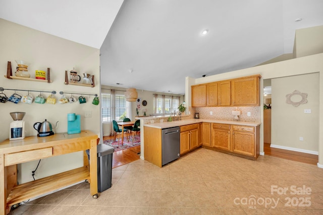 145 Fairway View Dr, Etowah, NC 28729 - kitchen featuring a peninsula, stainless steel dishwasher, vaulted ceiling, light countertops, and backsplash