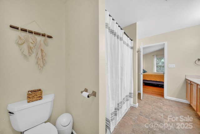 145 Fairway View Dr, Etowah, NC 28729 - ensuite bathroom with toilet, vanity, baseboards, stone finish floors, and a shower with curtain