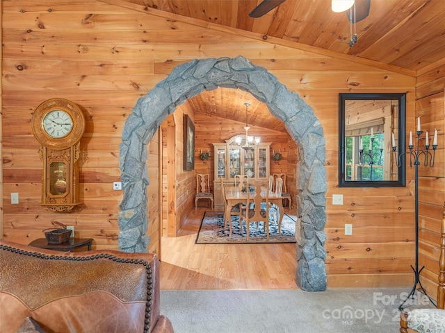 47 Tammy Dr, Maggie Valley, NC 28751 - carpeted dining space featuring vaulted ceiling, wood walls, a chandelier, arched walkways, and wooden ceiling