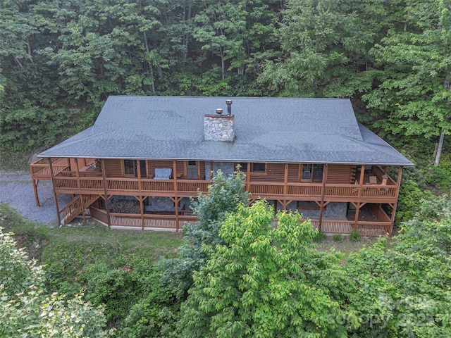 47 Tammy Dr, Maggie Valley, NC 28751 - rear view of house featuring log siding, a chimney, a view of trees, and a shingled roof