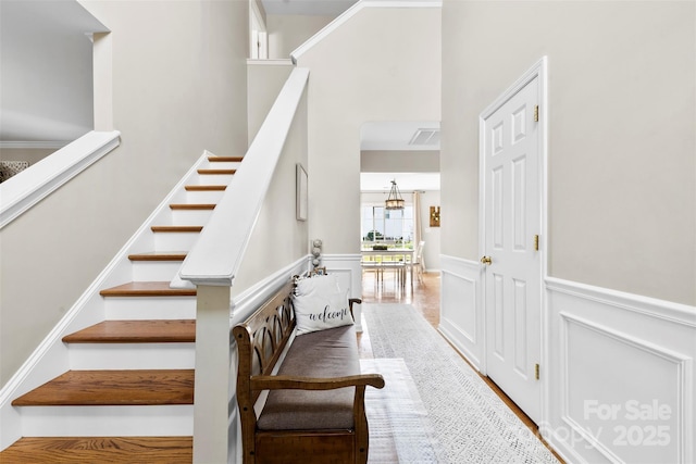 4612 Maple Crest Pl, Harrisburg, NC 28075 - stairs featuring wainscoting, a decorative wall, and a high ceiling