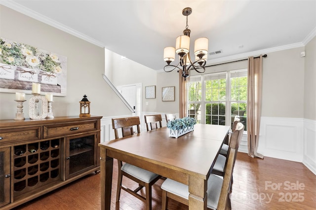 4612 Maple Crest Pl, Harrisburg, NC 28075 - dining area with ornamental molding, wainscoting, dark wood finished floors, a chandelier, and a decorative wall