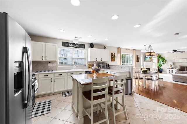 4612 Maple Crest Pl, Harrisburg, NC 28075 - kitchen with stainless steel fridge, open floor plan, light countertops, a sink, and backsplash