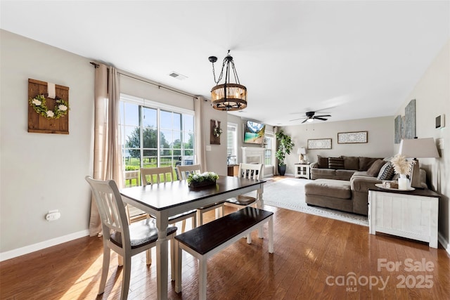4612 Maple Crest Pl, Harrisburg, NC 28075 - dining area featuring a chandelier, wood-type flooring, a ceiling fan, and baseboards