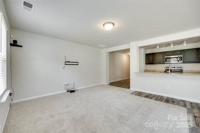 463 W Barr St, Lancaster, SC 29720 - unfurnished living room with rail lighting, carpet flooring, and baseboards