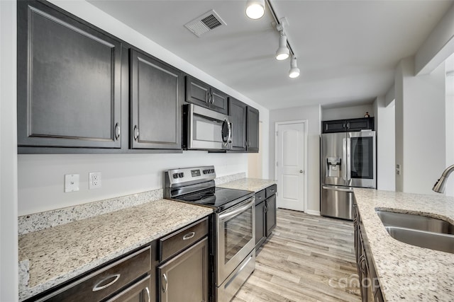 463 W Barr St, Lancaster, SC 29720 - kitchen featuring stainless steel appliances, a sink, light wood-style floors, light stone countertops, and rail lighting