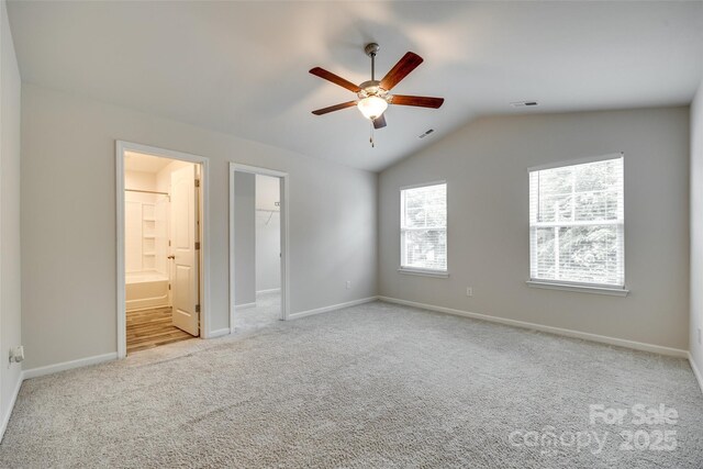463 W Barr St, Lancaster, SC 29720 - unfurnished bedroom with multiple windows, carpet floors, vaulted ceiling, baseboards, and a walk in closet