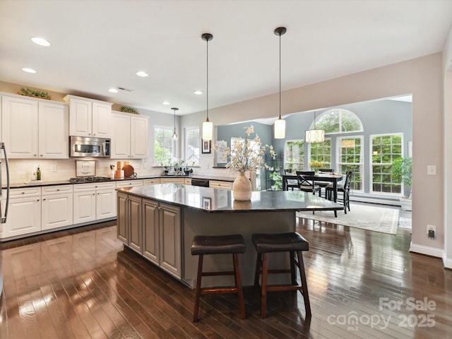 105 Beech Bluff Dr, Mount Holly, NC 28120 - kitchen with stainless steel microwave, dark wood-style floors, a kitchen island, backsplash, and recessed lighting
