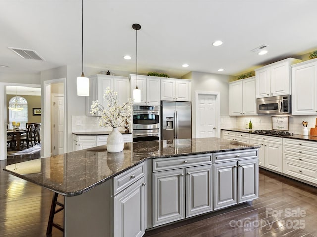 105 Beech Bluff Dr, Mount Holly, NC 28120 - kitchen with stainless steel appliances, a kitchen island, dark wood-type flooring, white cabinets, and recessed lighting