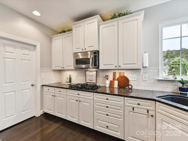 105 Beech Bluff Dr, Mount Holly, NC 28120 - kitchen with stainless steel microwave, black gas stovetop, white cabinetry, dark wood-style flooring, and dark stone countertops