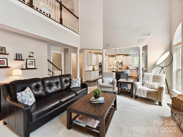 105 Beech Bluff Dr, Mount Holly, NC 28120 - living area with decorative columns, a high ceiling, stairs, and light carpet