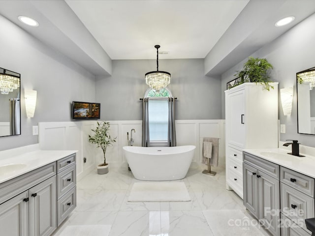 105 Beech Bluff Dr, Mount Holly, NC 28120 - full bathroom with a chandelier, a decorative wall, two vanities, wainscoting, and marble finish flooring