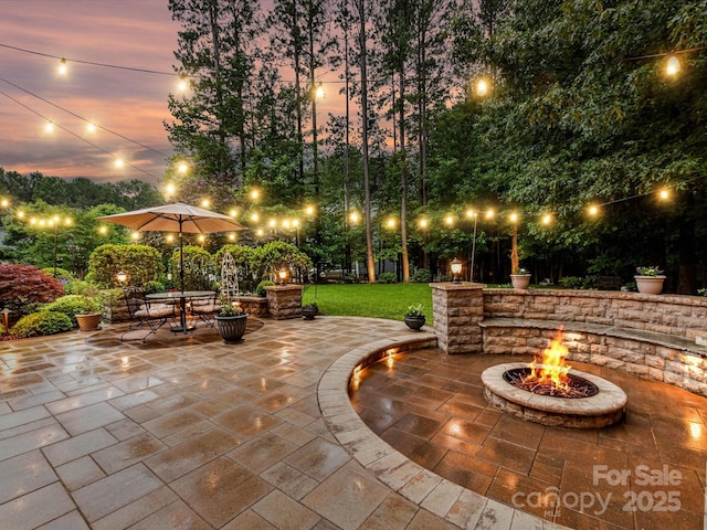 105 Beech Bluff Dr, Mount Holly, NC 28120 - patio terrace at dusk featuring an outdoor fire pit, a patio area, and a lawn
