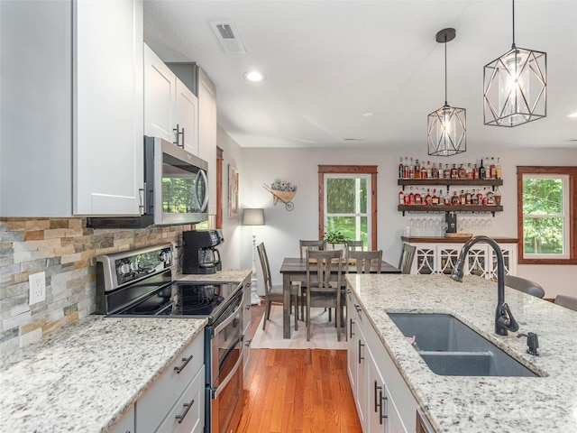 1903 Mauney Cove Rd, Waynesville, NC 28786 - kitchen with appliances with stainless steel finishes, white cabinetry, light wood-type flooring, recessed lighting, and pendant lighting
