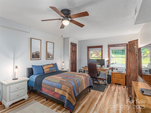 1903 Mauney Cove Rd, Waynesville, NC 28786 - bedroom featuring light wood-style floors, multiple windows, a desk, and a ceiling fan