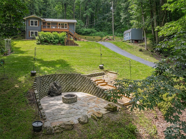 1903 Mauney Cove Rd, Waynesville, NC 28786 - view of grassy yard featuring stairs, a fire pit, a wooden deck, and a view of trees