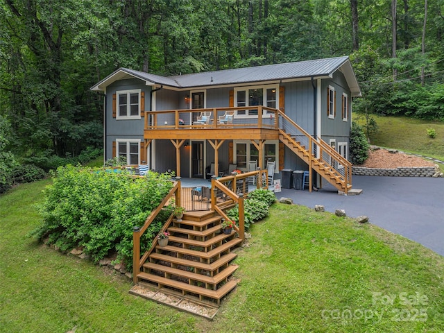 1903 Mauney Cove Rd, Waynesville, NC 28786 - view of front facade with stairs, a front lawn, a metal roof, a deck, and a wooded view