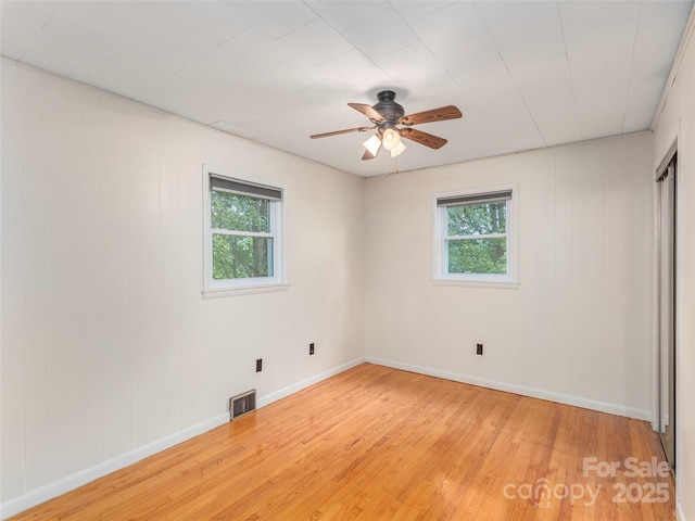 151 Ingram Loop, Clyde, NC 28721 - unfurnished bedroom featuring multiple windows, light wood-type flooring, baseboards, and ceiling fan