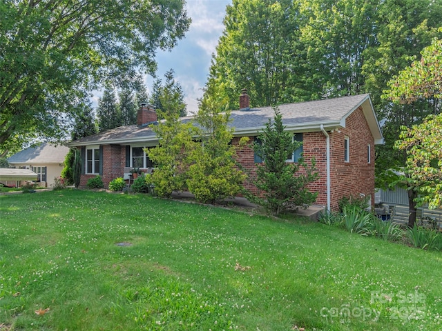 151 Ingram Loop, Clyde, NC 28721 - ranch-style house featuring a chimney, brick siding, and a front yard