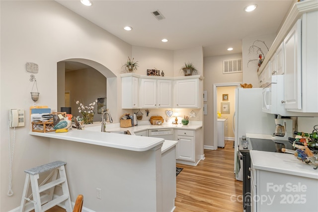 73 Ridgetop Cir Unit 302, Brevard, NC 28712 - kitchen with white appliances, a breakfast bar, arched walkways, white cabinets, and recessed lighting