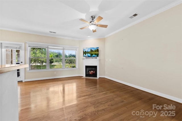 2765 Clover Rd NW, Concord, NC 28027 - unfurnished living room featuring wood finished floors, a fireplace with flush hearth, a ceiling fan, ornamental molding, and baseboards