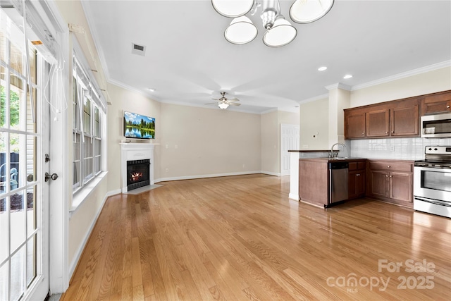 2765 Clover Rd NW, Concord, NC 28027 - kitchen featuring stainless steel appliances, a ceiling fan, crown molding, light wood-style floors, and tasteful backsplash