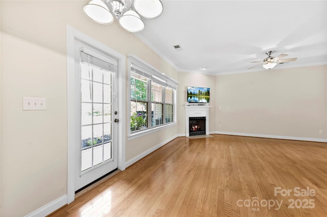 2765 Clover Rd NW, Concord, NC 28027 - unfurnished living room with light wood-type flooring, ornamental molding, a fireplace with flush hearth, baseboards, and a chandelier