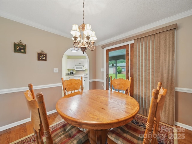 733 Killian Rd, Stanley, NC 28164 - dining space featuring arched walkways, a chandelier, light wood-style floors, crown molding, and baseboards