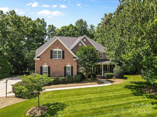 1336 Dobson Dr, Waxhaw, NC 28173 - view of front facade featuring brick siding, a front yard, and covered porch