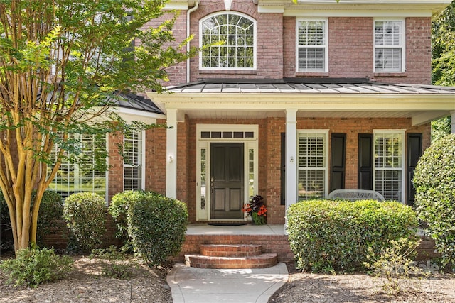 1336 Dobson Dr, Waxhaw, NC 28173 - property entrance with a porch, a standing seam roof, and brick siding