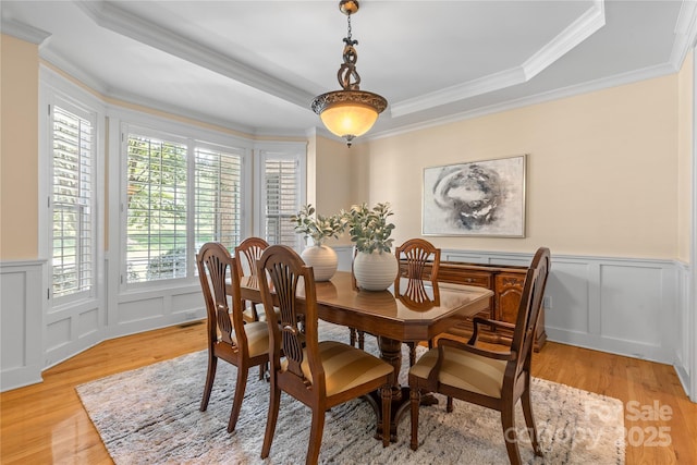 1336 Dobson Dr, Waxhaw, NC 28173 - dining area with a decorative wall, light wood-style floors, ornamental molding, wainscoting, and a tray ceiling