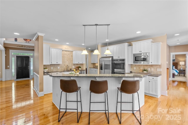 1336 Dobson Dr, Waxhaw, NC 28173 - kitchen featuring appliances with stainless steel finishes, white cabinetry, tasteful backsplash, recessed lighting, and crown molding