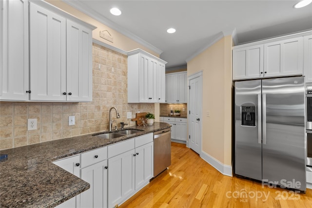1336 Dobson Dr, Waxhaw, NC 28173 - kitchen featuring stainless steel appliances, ornamental molding, light wood-style flooring, white cabinetry, and decorative backsplash