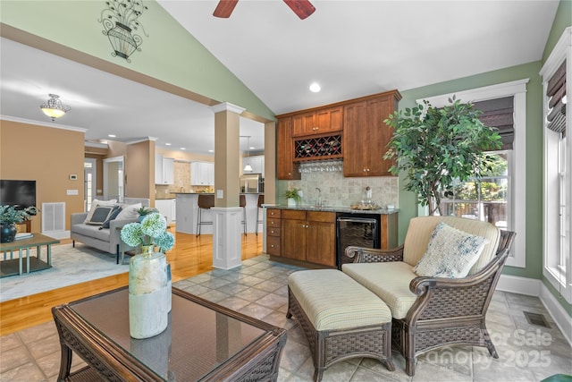 1336 Dobson Dr, Waxhaw, NC 28173 - living area with wine cooler, bar with sink, vaulted ceiling, a ceiling fan, and recessed lighting