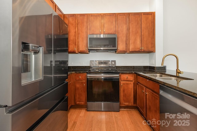 3271 Noda Blvd, Charlotte, NC 28205 - kitchen featuring appliances with stainless steel finishes, light wood-style floors, dark stone countertops, and brown cabinets