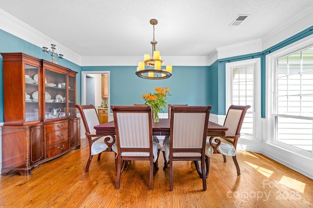 12712 Hollyhock Ln, Huntersville, NC 28078 - dining space featuring a chandelier, a textured ceiling, light wood-style flooring, and ornamental molding