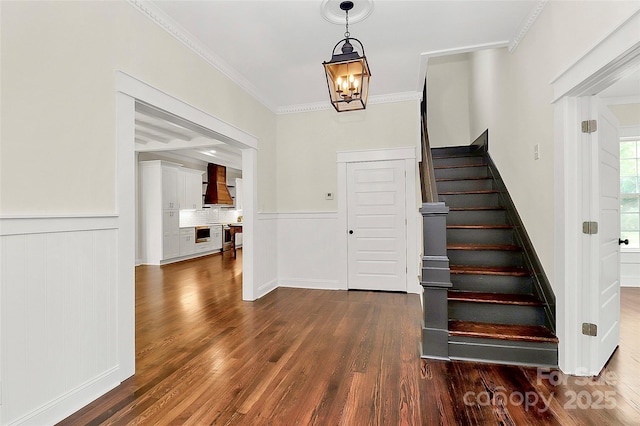 604 Ferguson Ridge Rd, Gastonia, NC 28052 - stairway featuring wood finished floors, a chandelier, ornamental molding, and a wainscoted wall