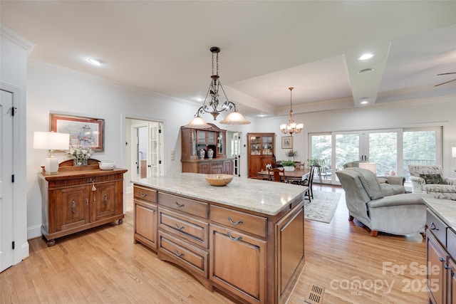 103 3rd St SW, Catawba, NC 28609 - kitchen featuring light wood finished floors, ornamental molding, light stone counters, a chandelier, and brown cabinets