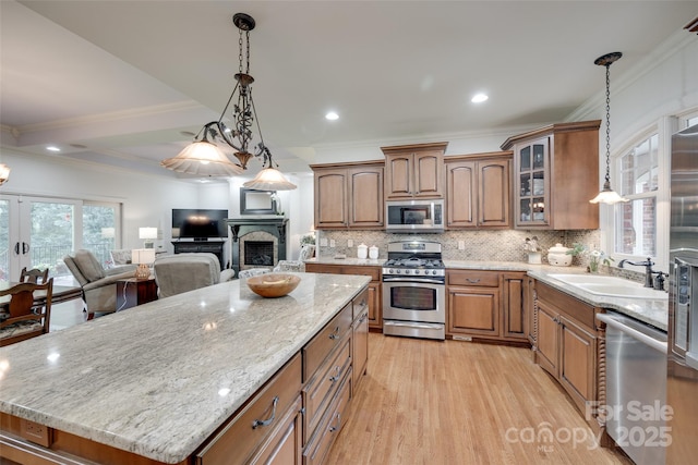 103 3rd St SW, Catawba, NC 28609 - kitchen with stainless steel appliances, brown cabinets, a center island, decorative backsplash, and light wood finished floors